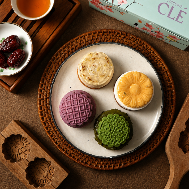Pâtisserie CLÉ Mid-Autumn Gift Box open to reveal four French entremet mooncakes, presented with a cherry blossom gift box and matching tote bag
