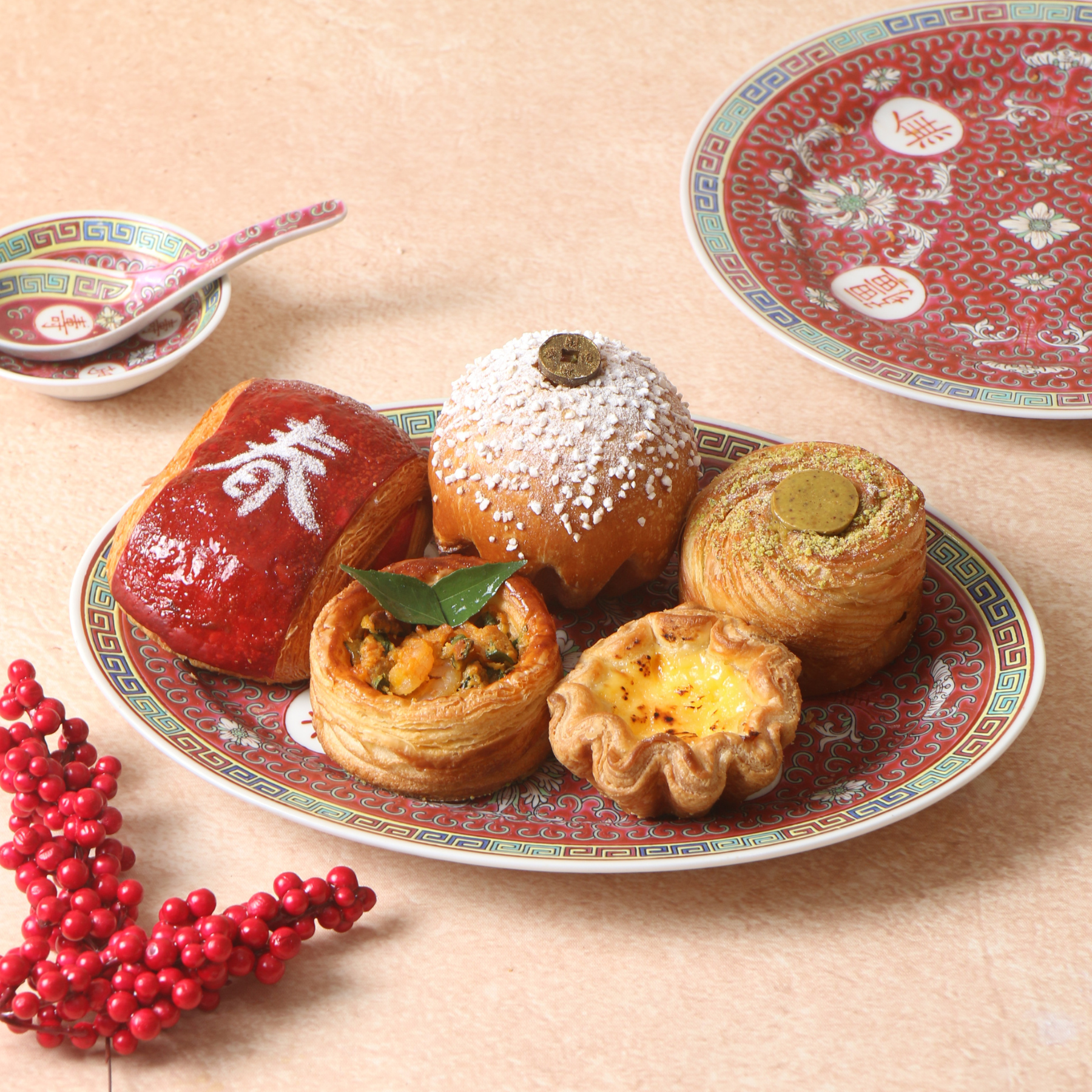 cny pastry Golden Blessings Pastry Gift Box styled on red plate with spoon and berries for Lunar New Year.