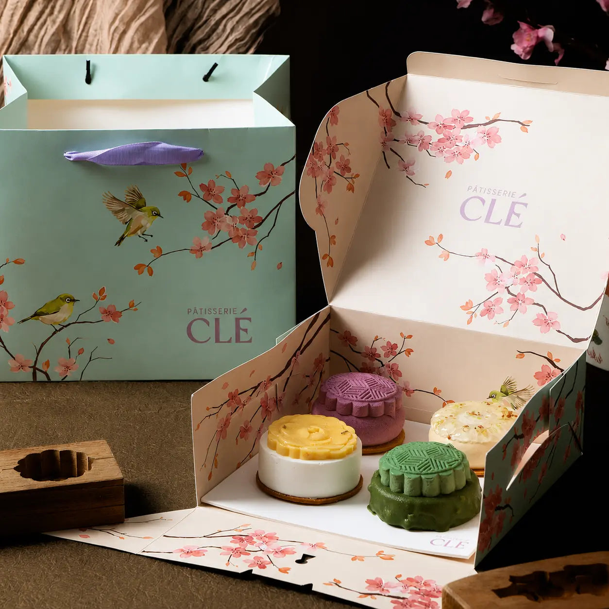 Mid Autumn Gift Box open to reveal four French entremet mooncakes, presented in a cherry blossom gift box with matching tote bag.